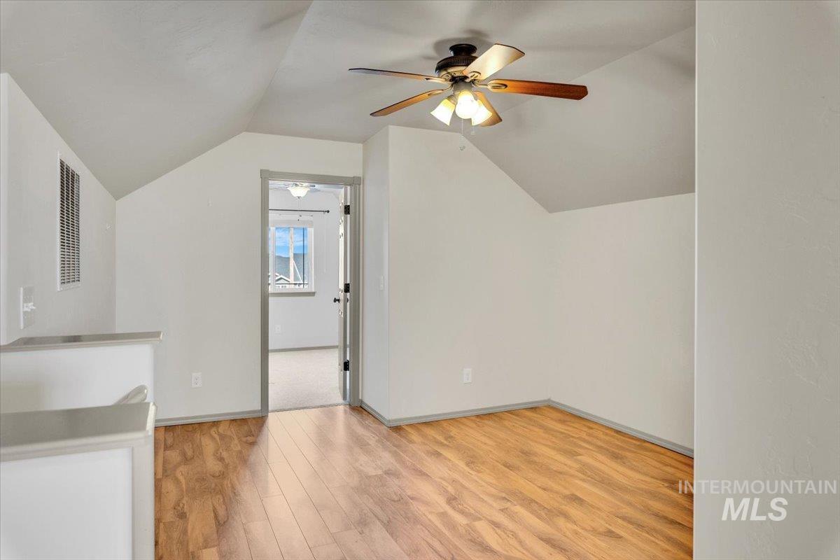 Additional living space featuring light wood-style floors and ceiling fan