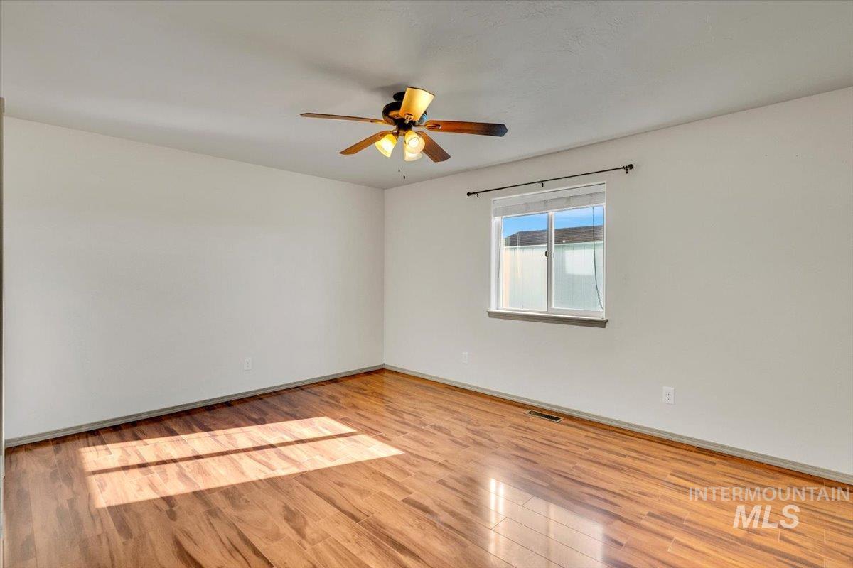Empty room with light wood-type flooring and a ceiling fan