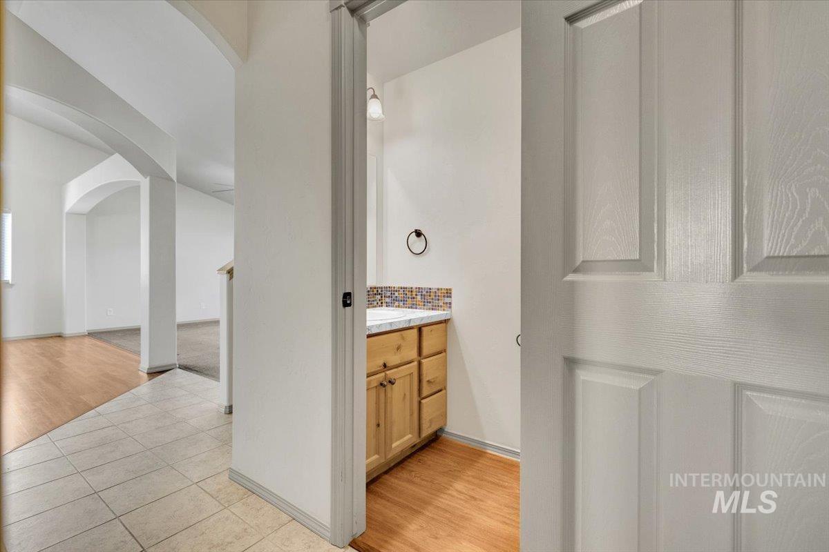 Bathroom with light tile patterned floors, vanity, and decorative backsplash