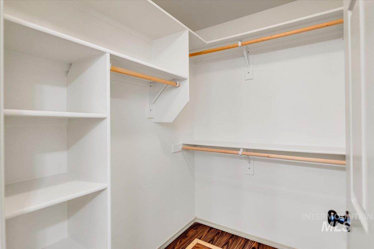 Walk in closet featuring dark wood-type flooring