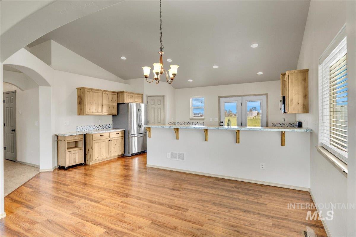 Kitchen featuring a kitchen breakfast bar, a peninsula, vaulted ceiling, arched walkways