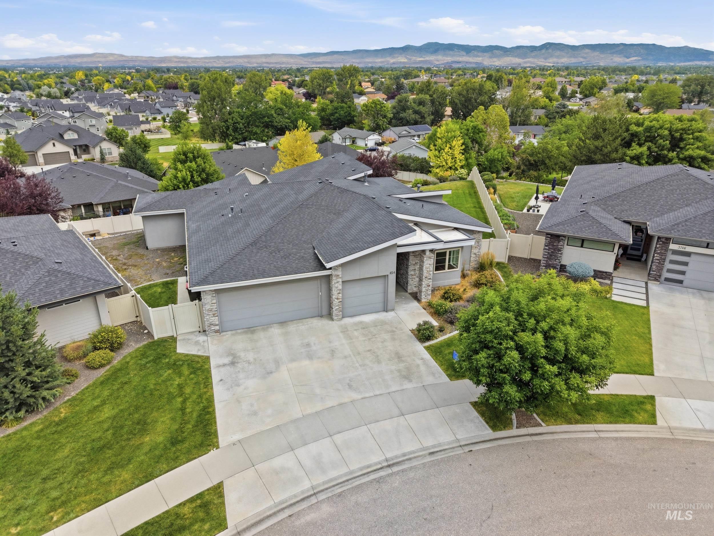 Contemporary residence with a multi-car garage, stone accents, and a landscaped front yard