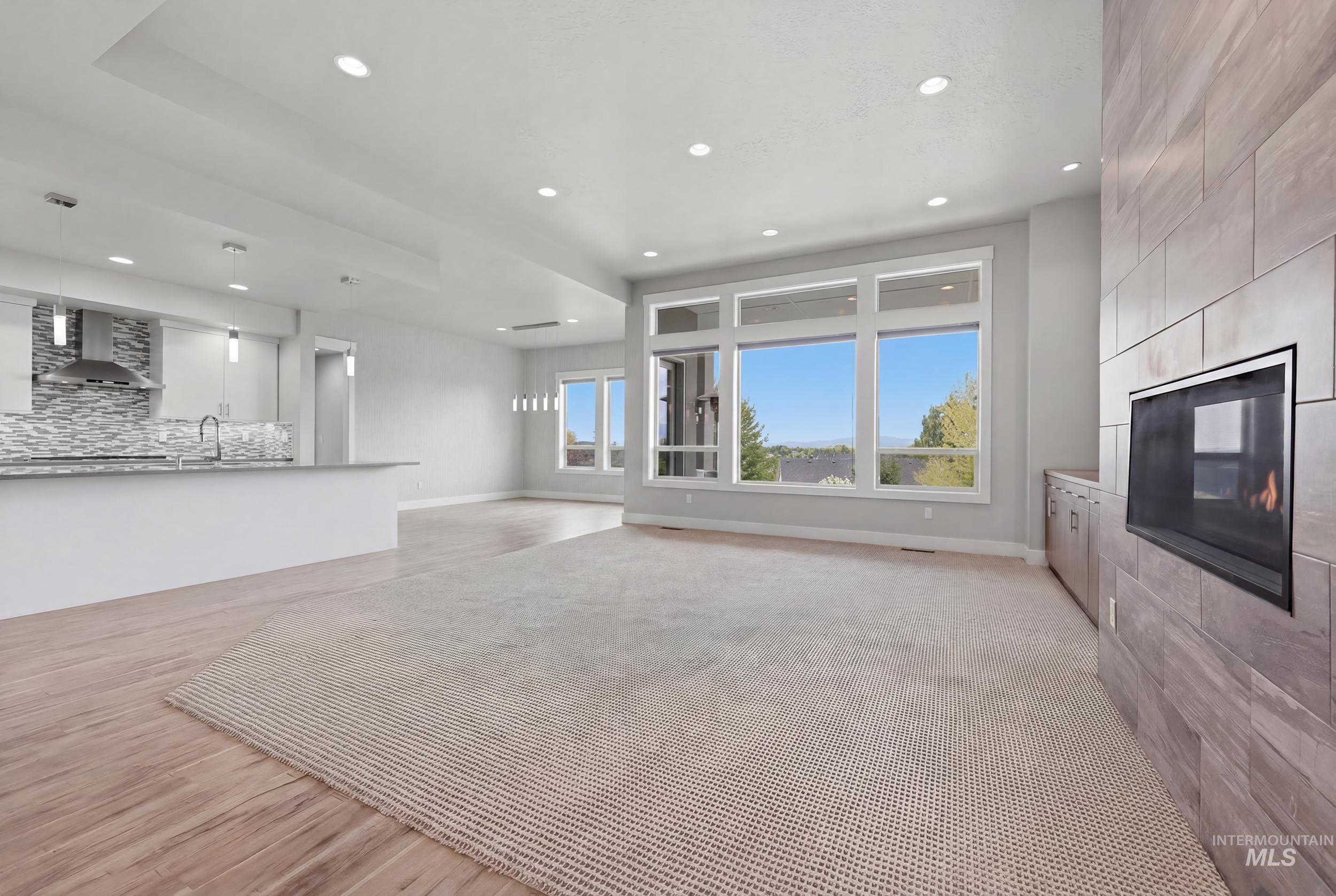 Open-concept living area with a contemporary fireplace featuring a stone-look tile surround and integrated media console