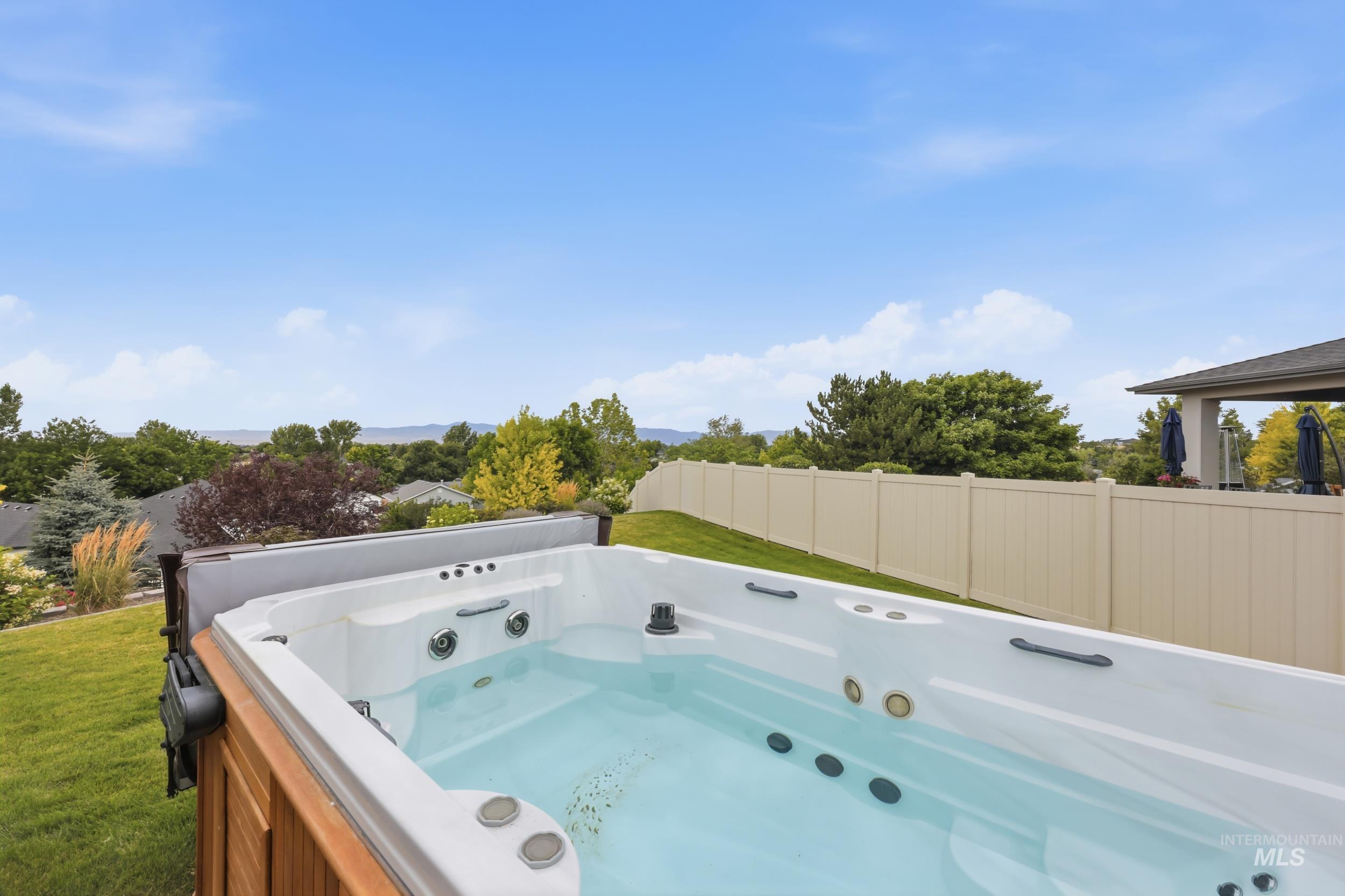 Outdoor swim spa with a wood-finish surround, set on a manicured lawn