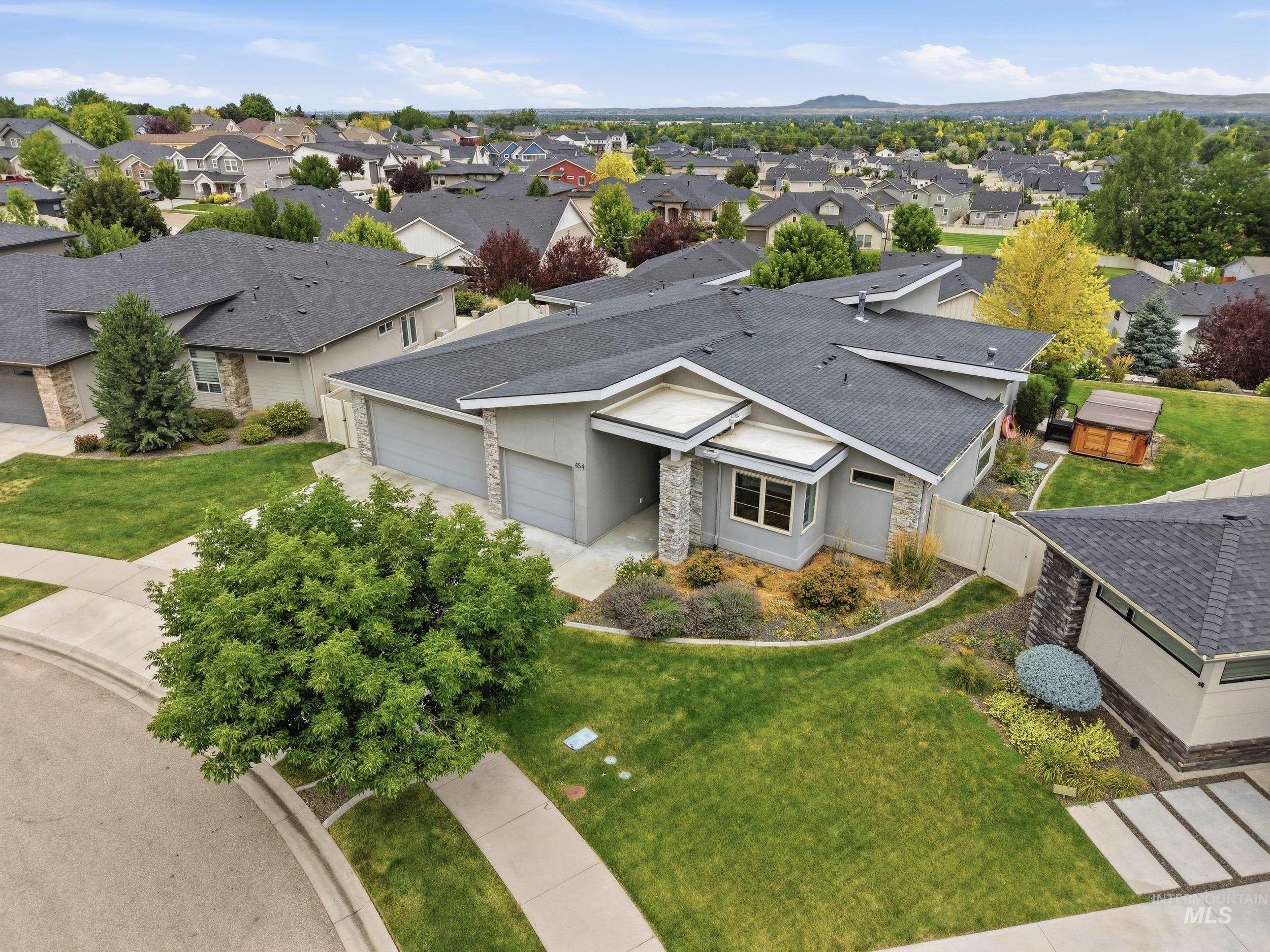Contemporary residence featuring a multi-gabled roofline and stone accent pillars