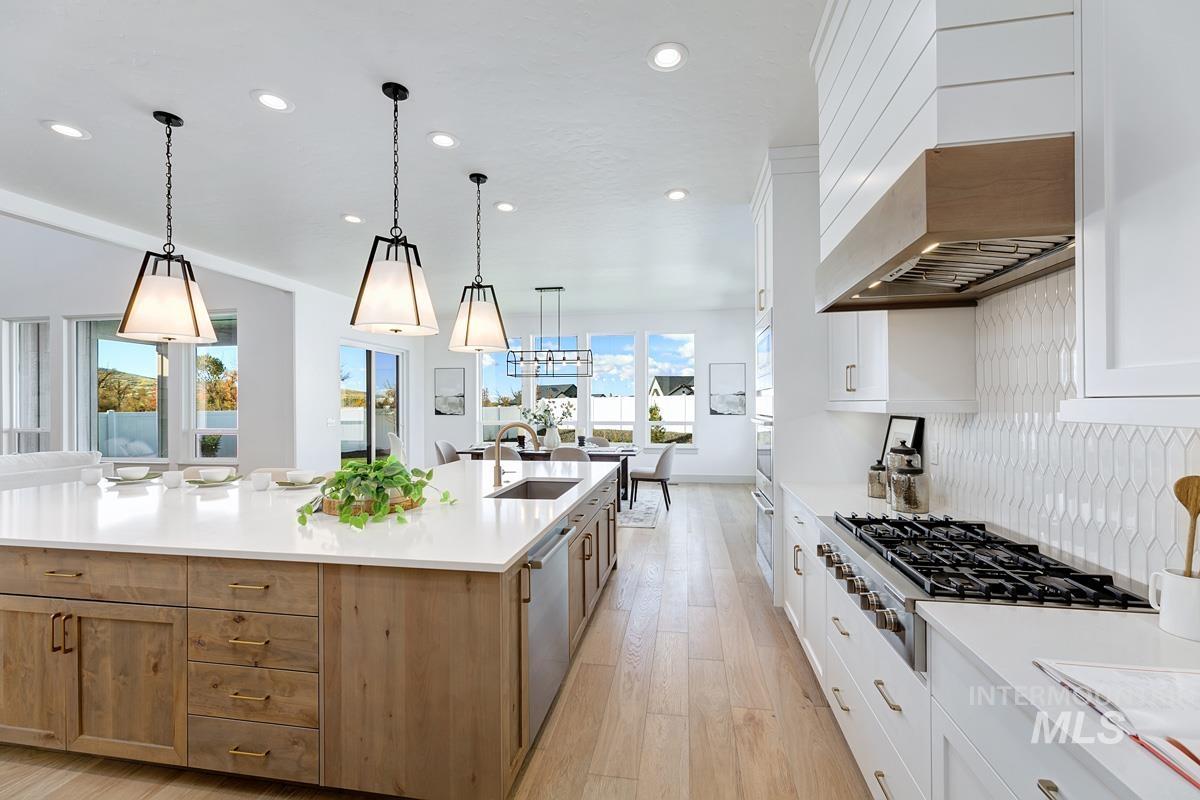 Kitchen featuring white cabinetry, recessed lighting, light wood-style flooring, appliances with stainless steel finishes, and pendant lighting