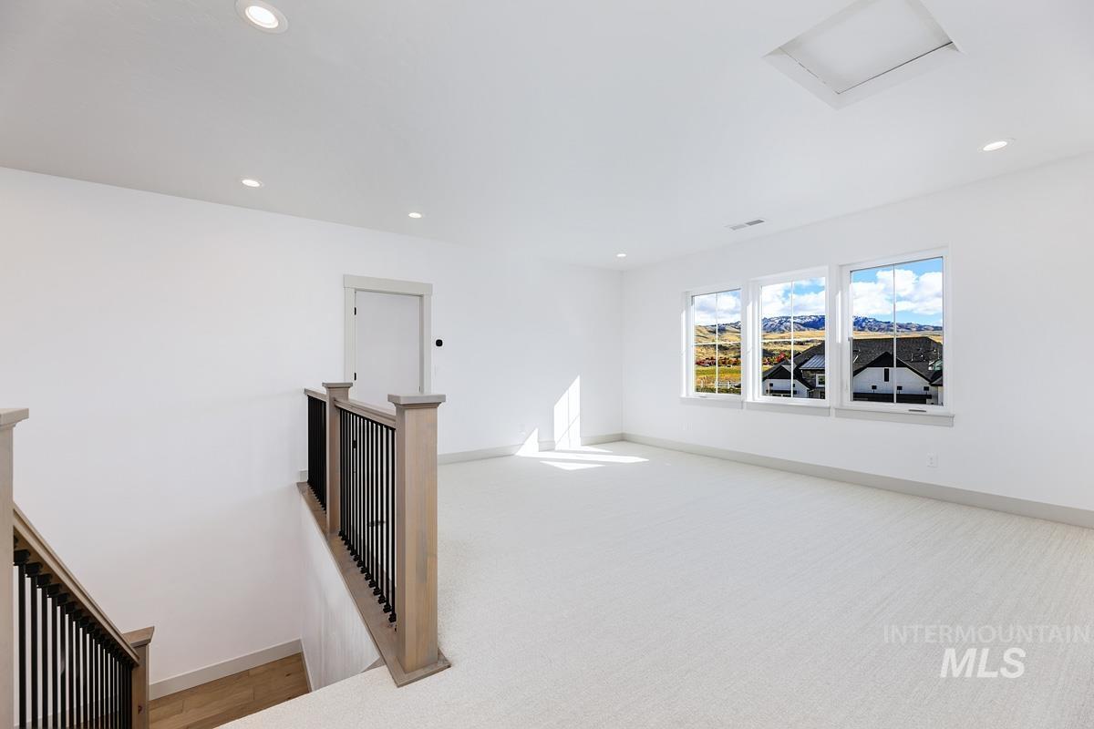 Empty room featuring recessed lighting, attic access, and light colored carpet