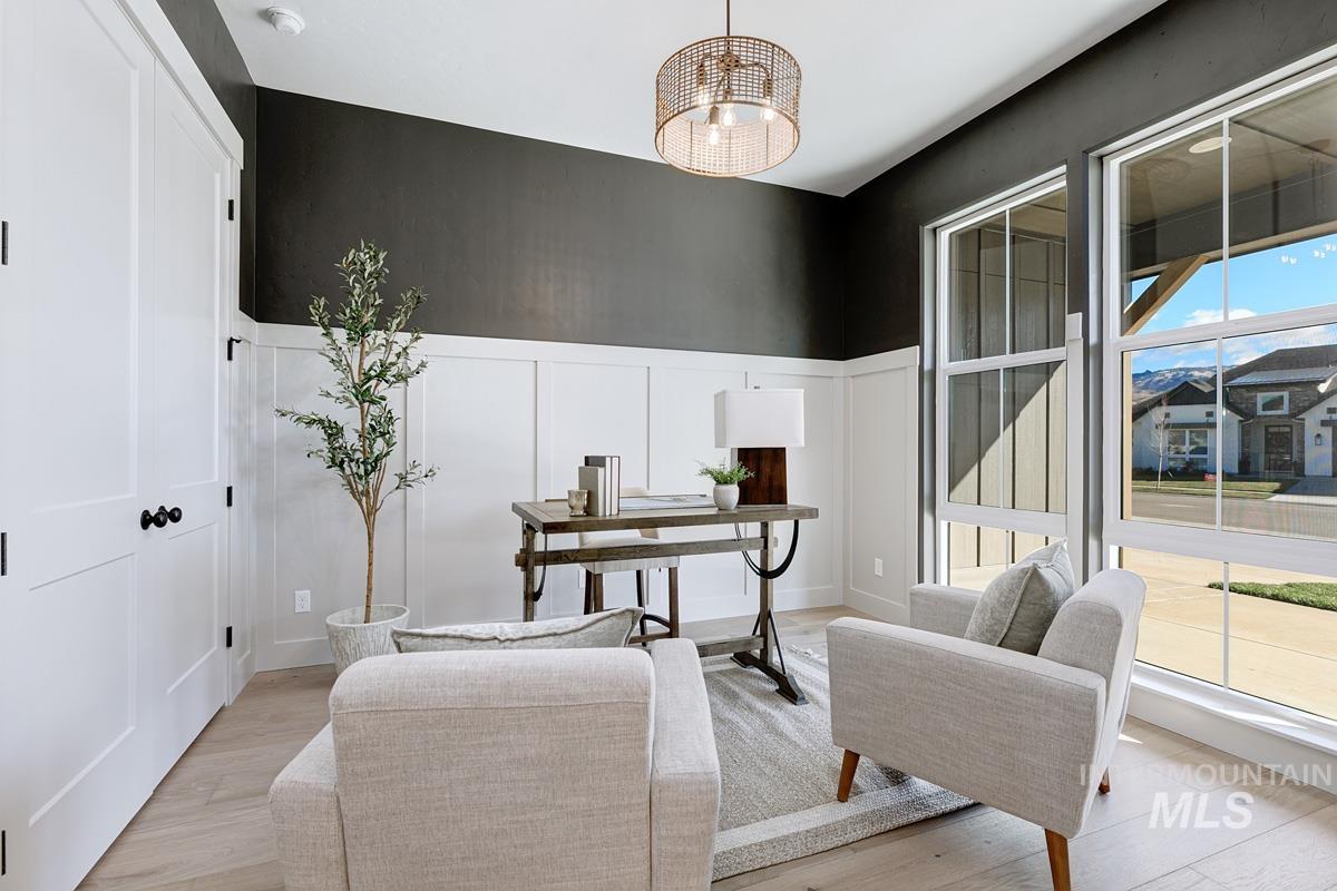 Office with a decorative wall, a wainscoted wall, and wood finished floors