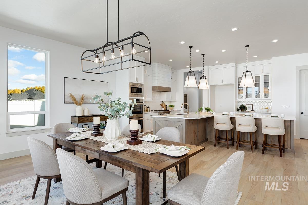 Dining area with light wood-style flooring and recessed lighting