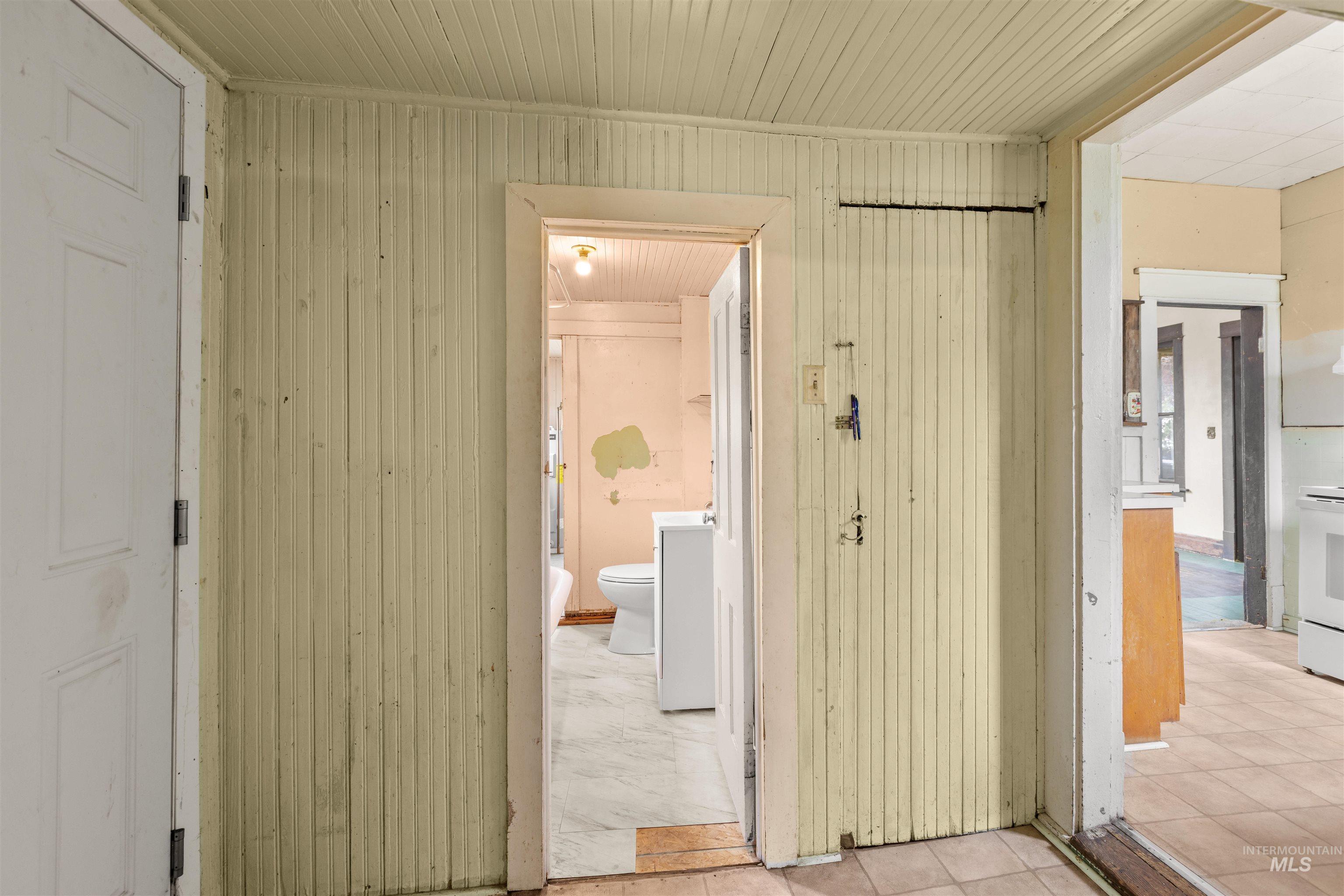 Interior hallway featuring vertical wood paneling and wood-finish ceiling