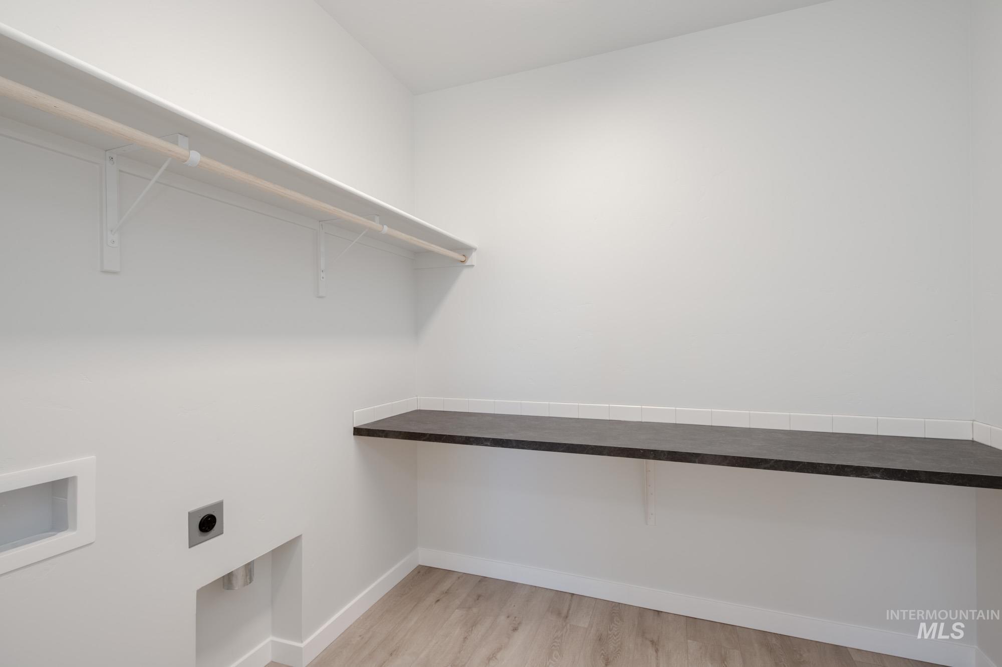 Washroom with light wood finished floors and electric dryer hookup