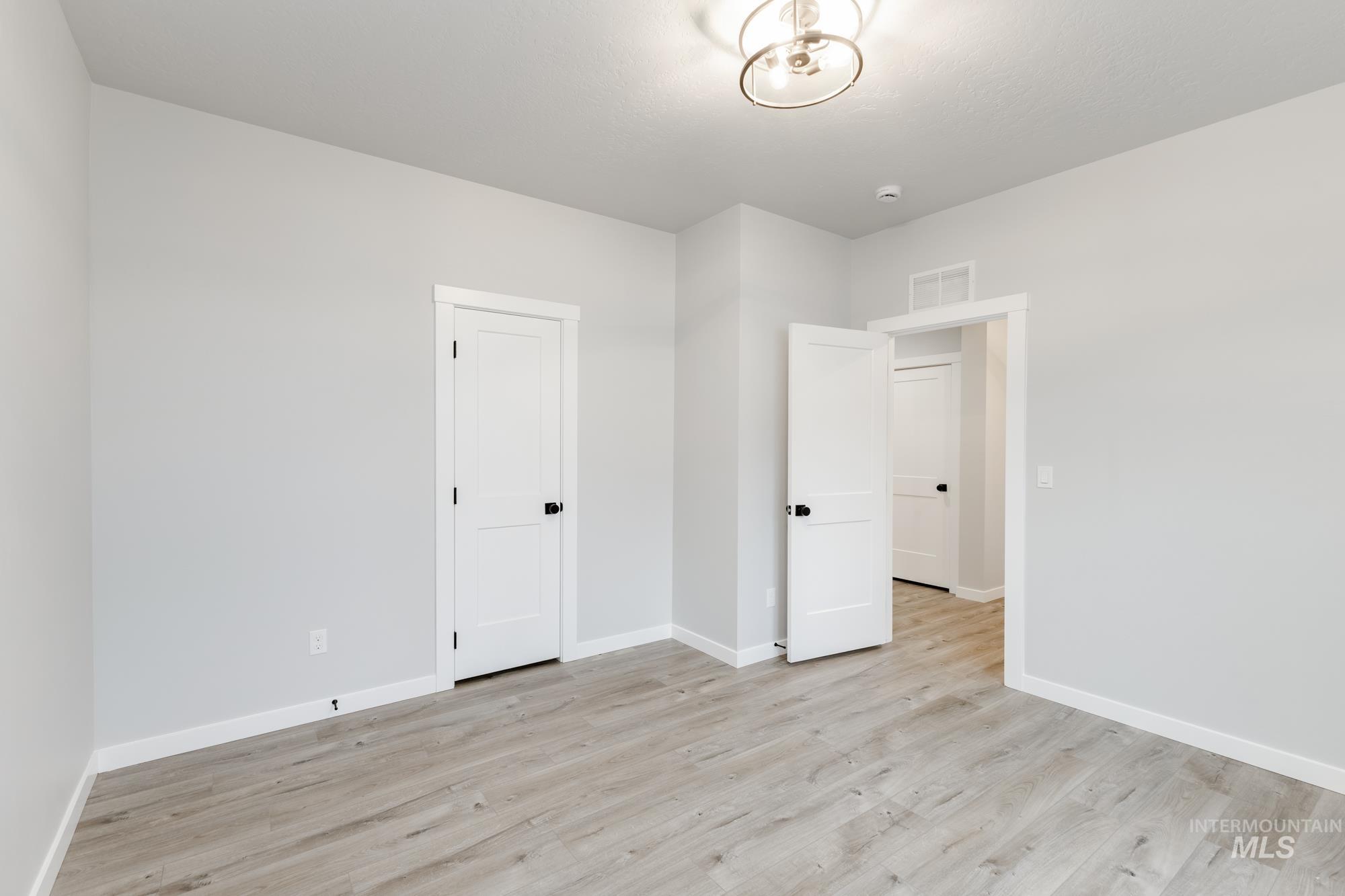 Unfurnished bedroom with baseboards and light wood-style floors