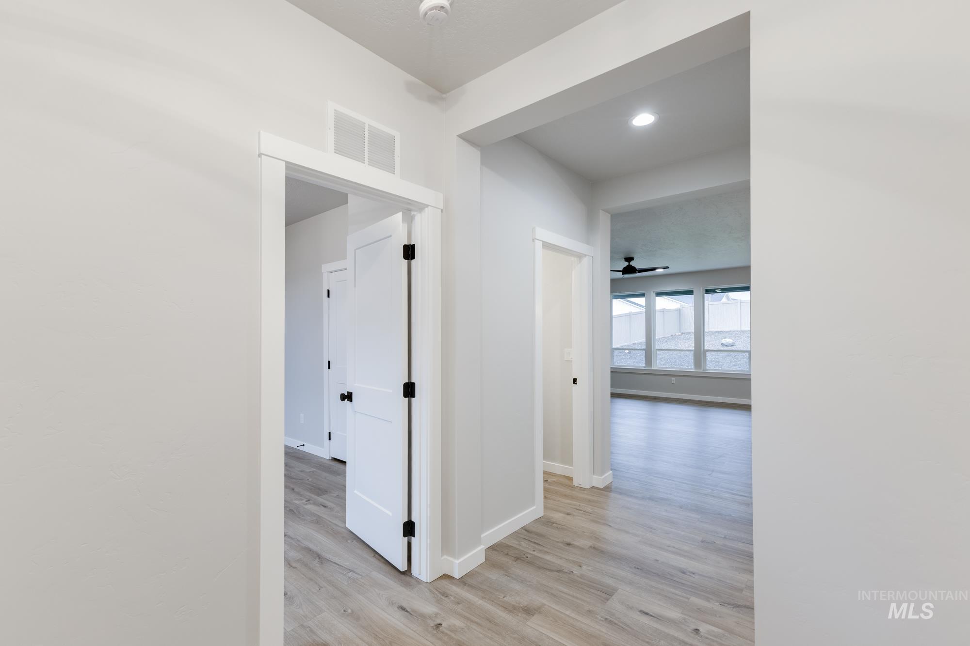 Corridor featuring light wood-type flooring and baseboards