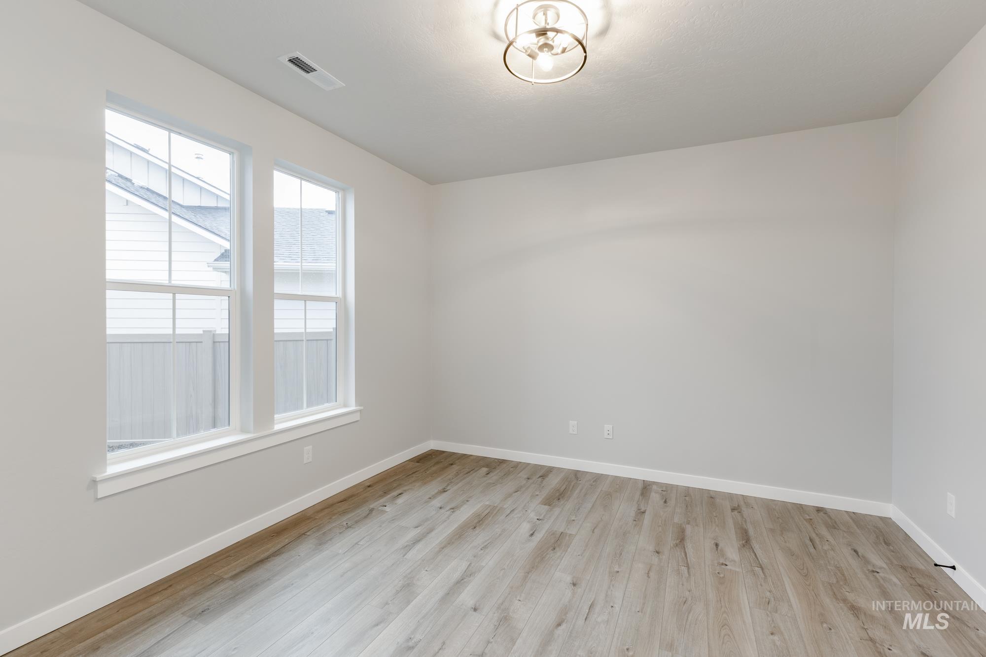 Spare room with baseboards and light wood-style flooring