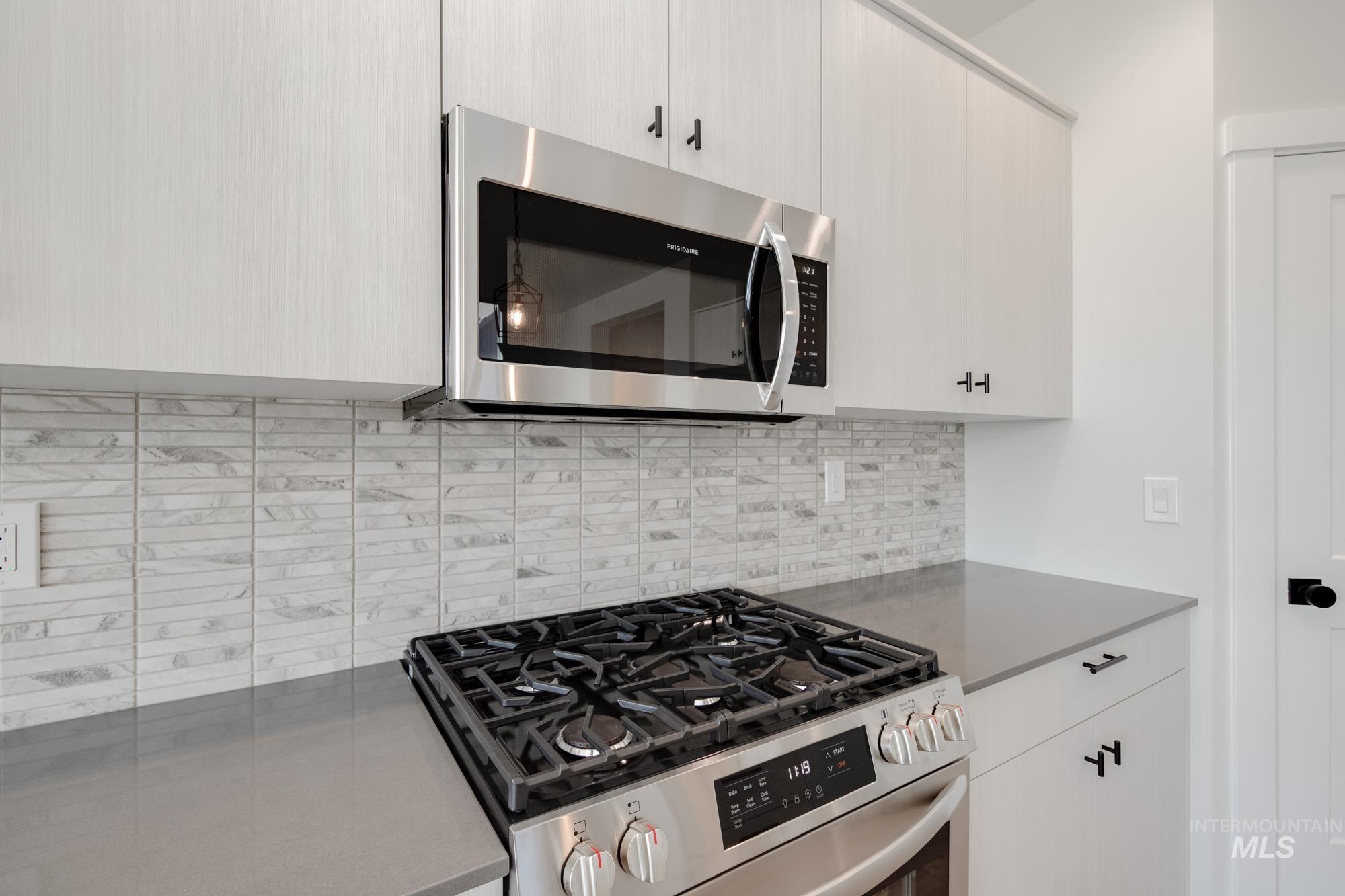 Kitchen featuring stainless steel appliances, tasteful backsplash, and modern cabinets