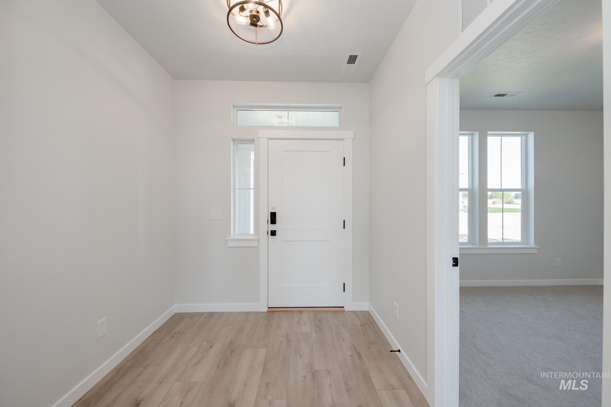 Entrance foyer featuring baseboards and light wood finished floors