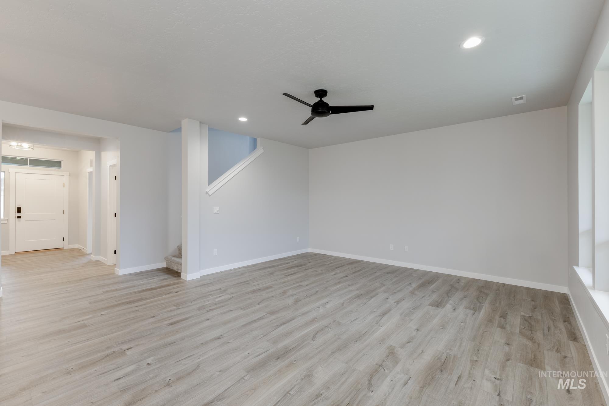 Spare room featuring light wood-style floors, a ceiling fan, and recessed lighting