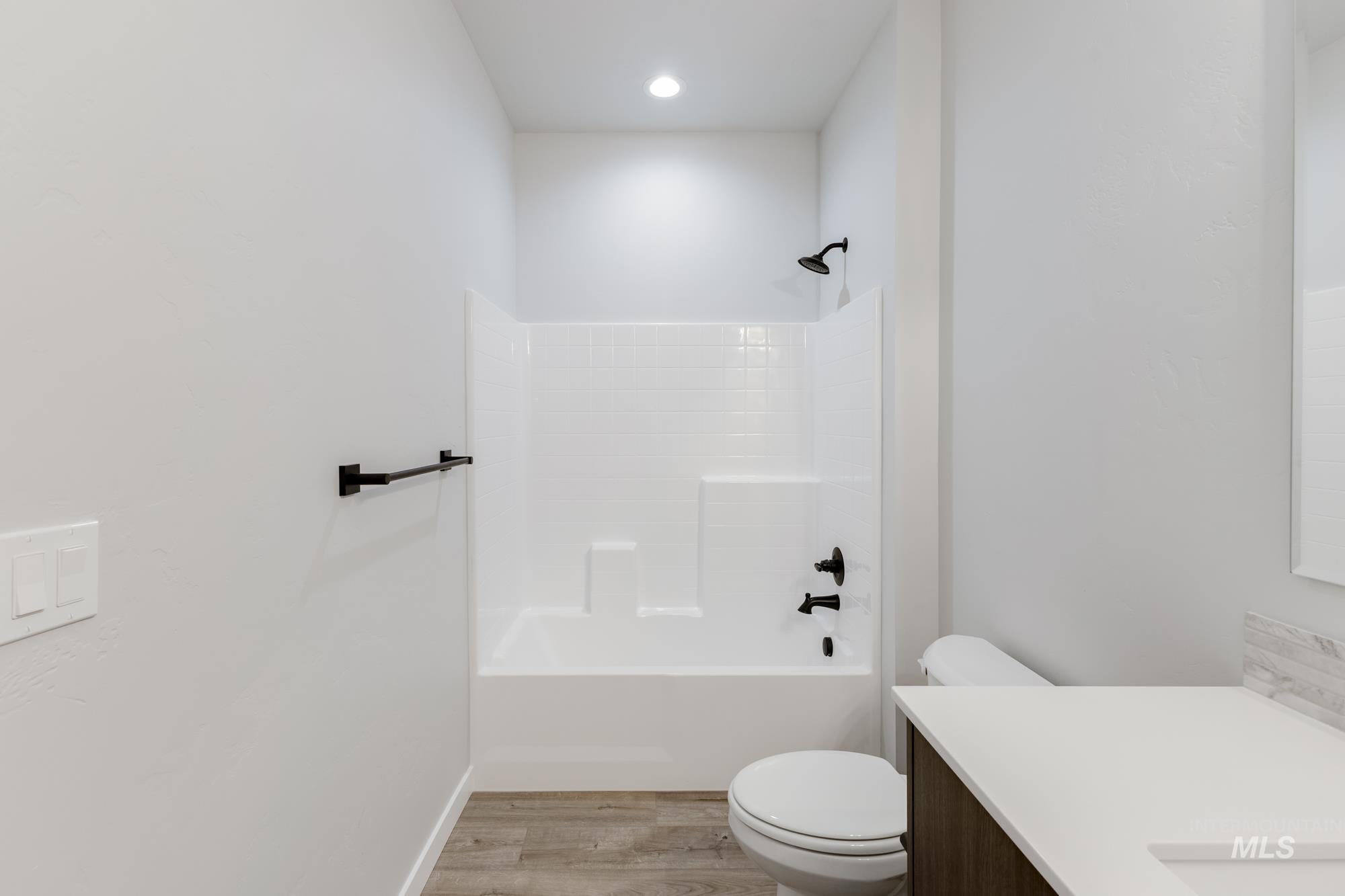 Full bath featuring vanity, light wood-style flooring, and tub / shower combination