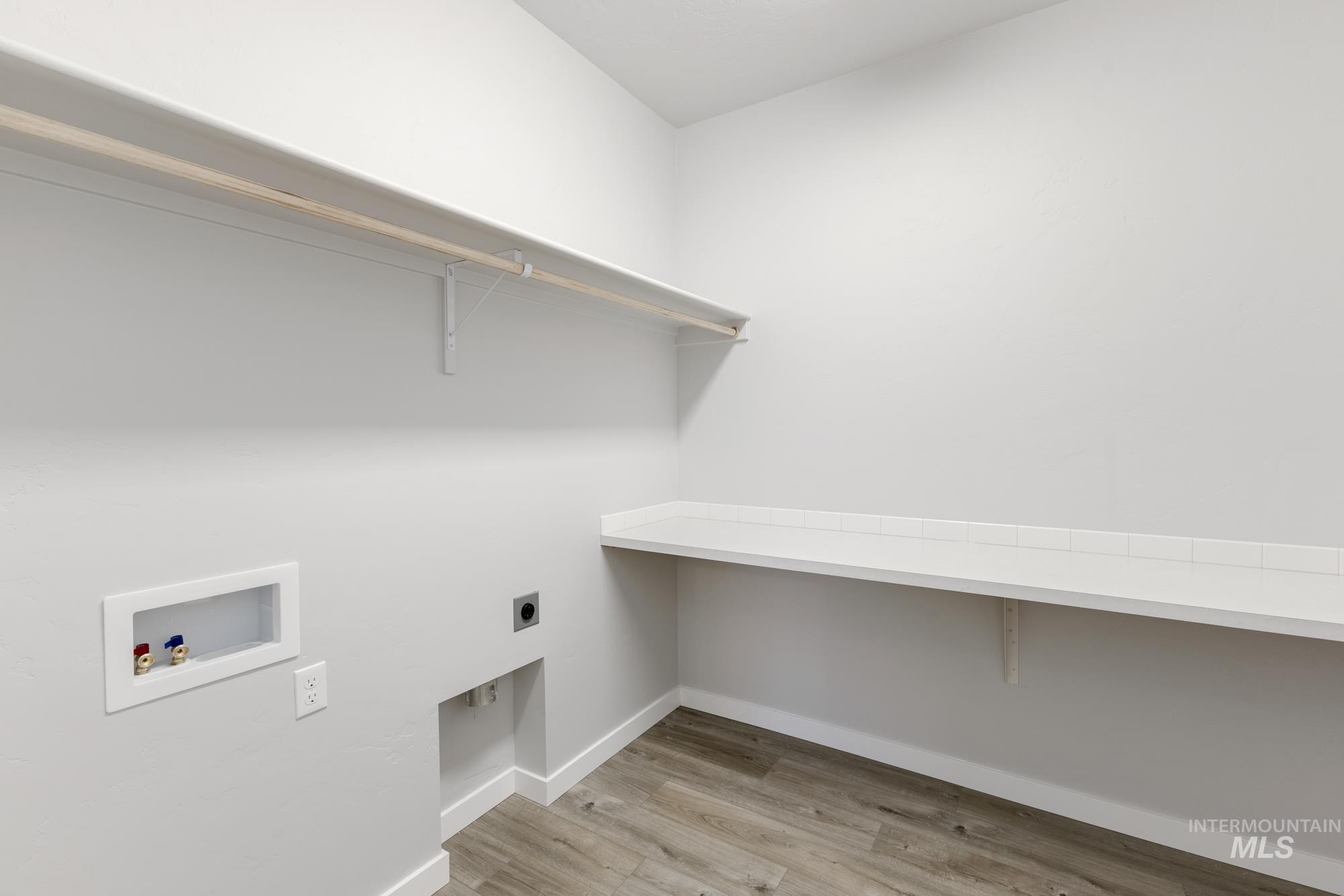 Laundry room with light wood-type flooring, washer hookup, and electric dryer hookup