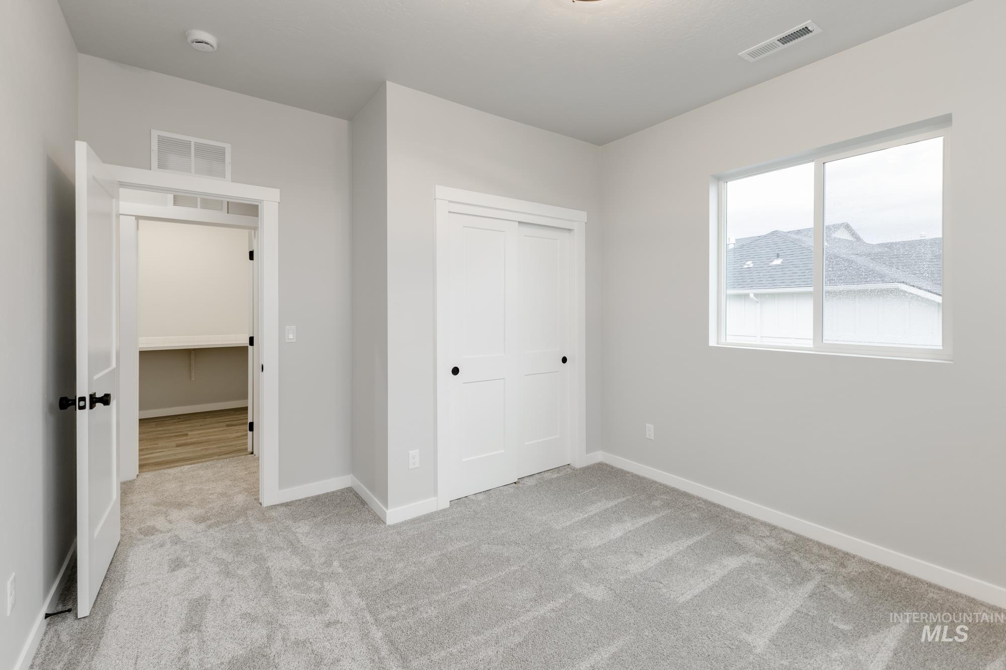 Unfurnished bedroom with a closet and light colored carpet