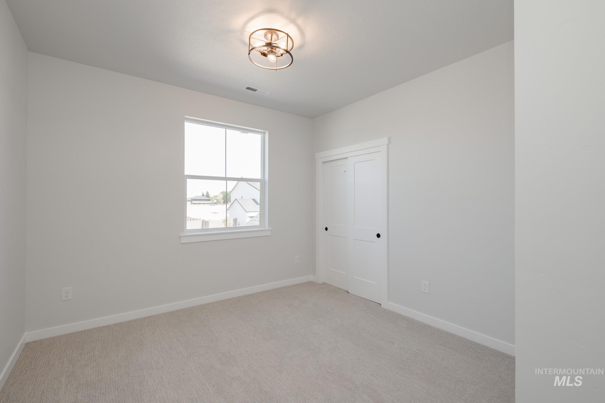 Empty room featuring baseboards and light colored carpet