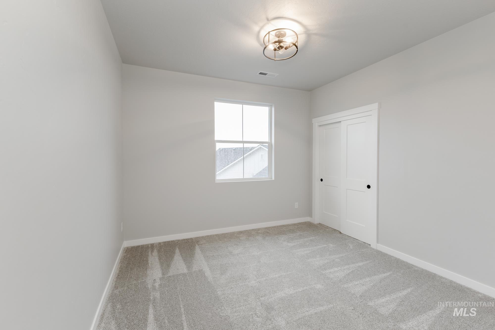 Empty room with light carpet and baseboards