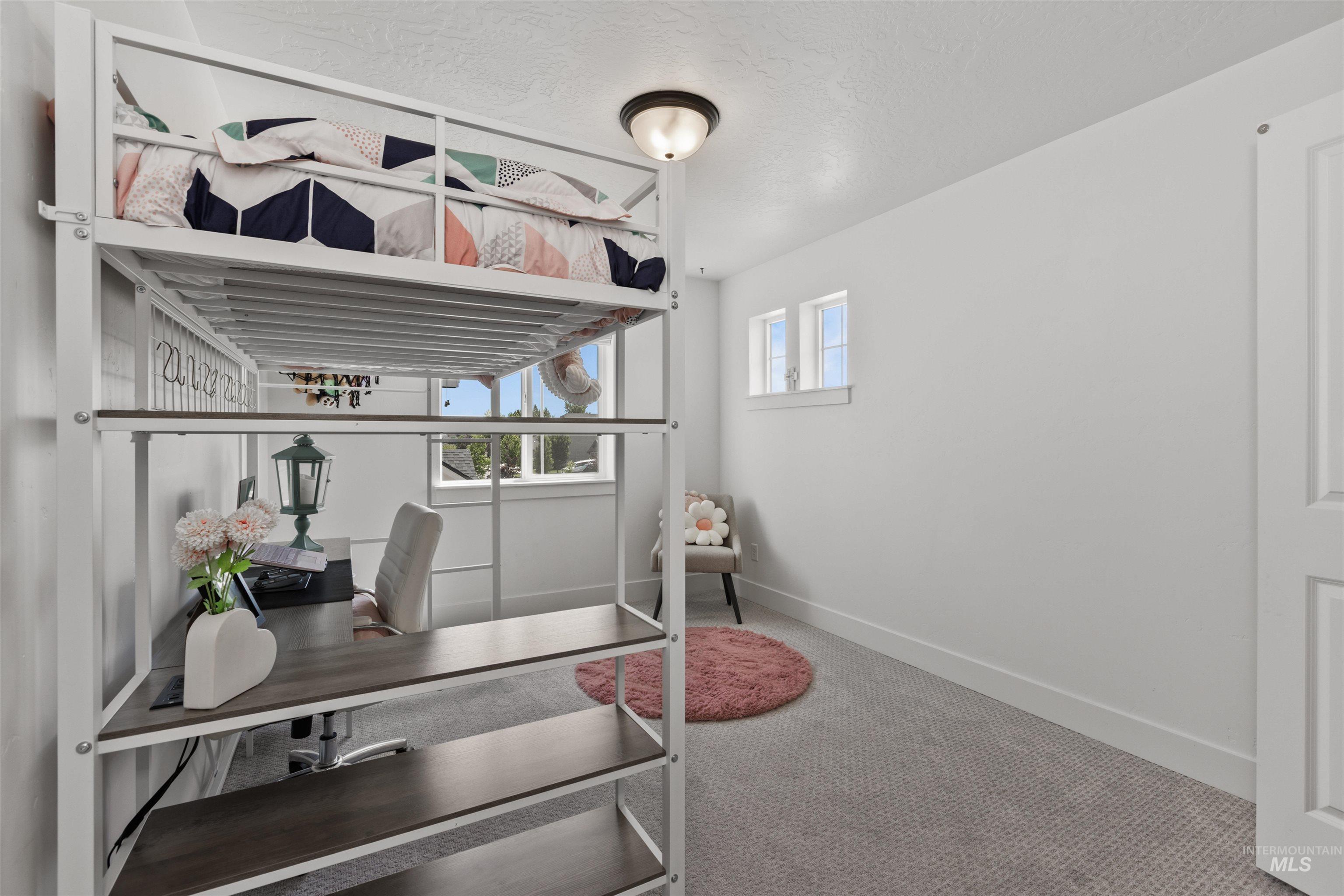 Office area featuring carpet floors and a textured ceiling