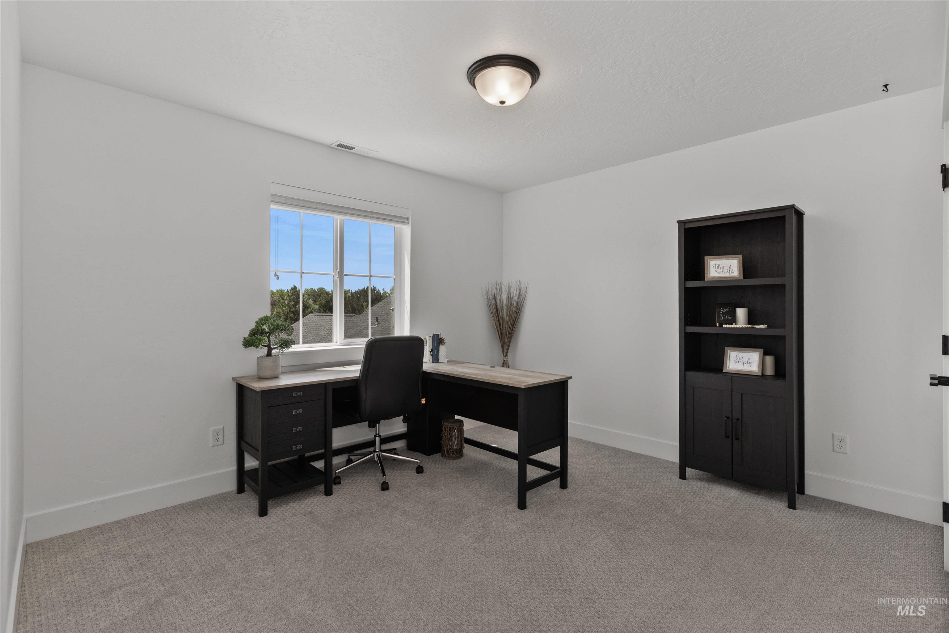 Office featuring light carpet and baseboards