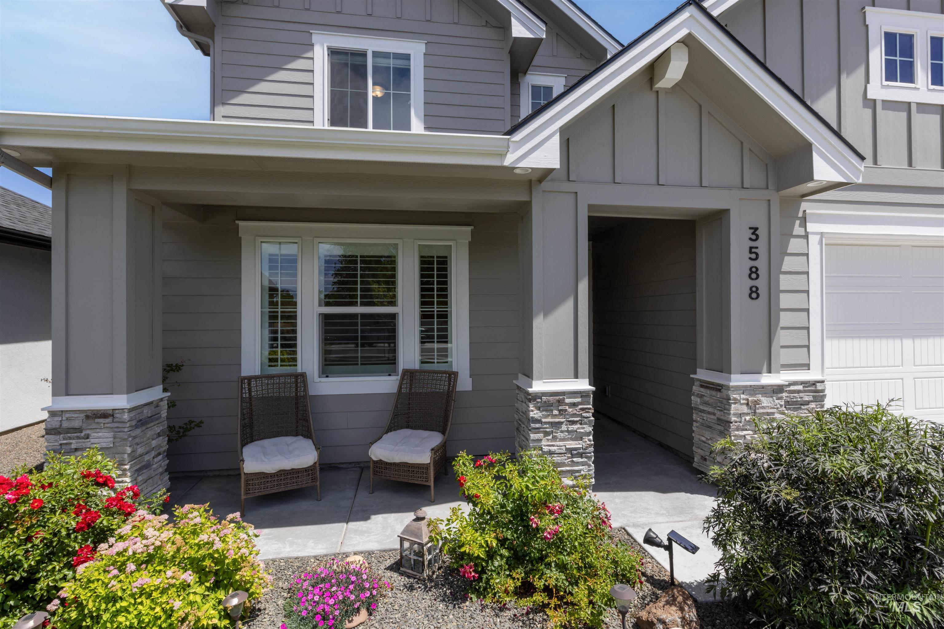 Entrance to property with board and batten siding, stone siding, and a garage