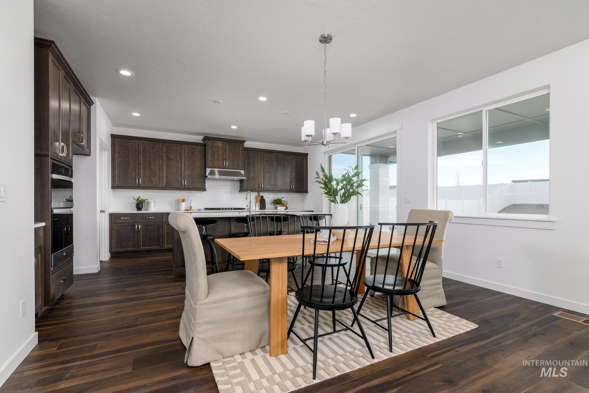 Dining space featuring dark wood-style flooring, a chandelier, and recessed lighting