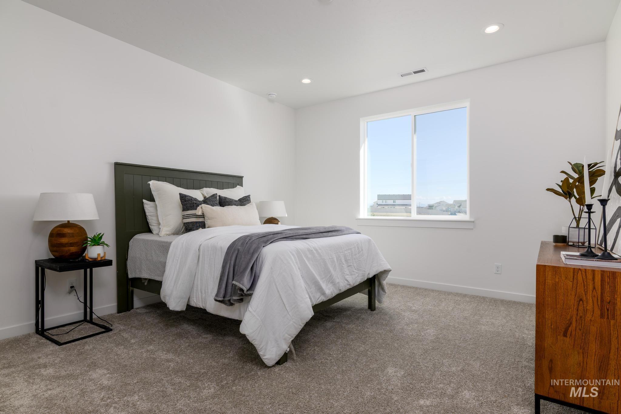 Bedroom with light colored carpet and recessed lighting