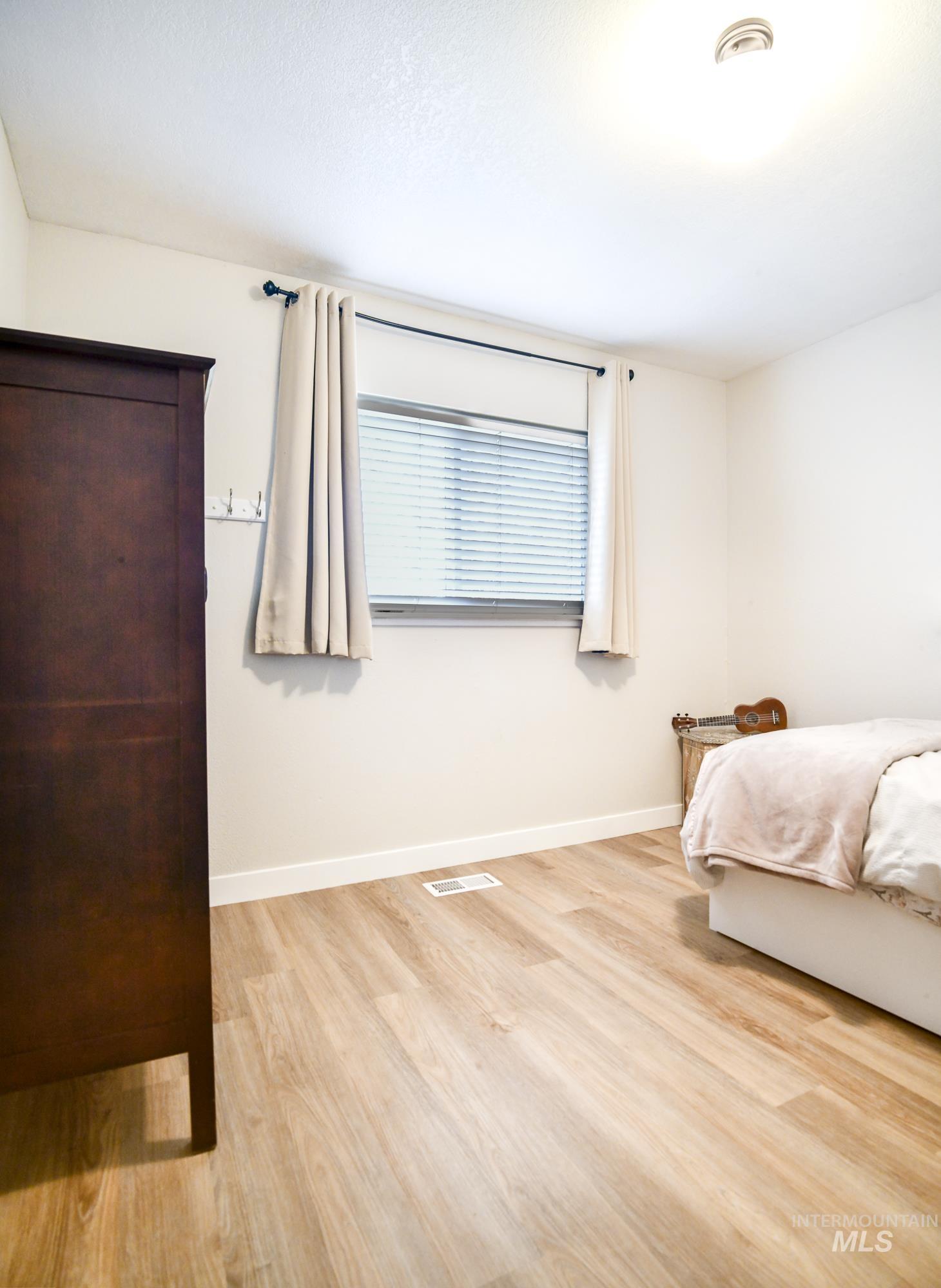 Bedroom with light wood-style flooring and baseboards