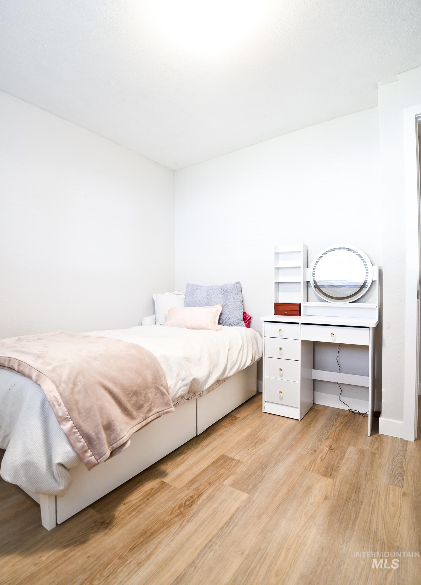 Bedroom with light wood-style flooring and an office area