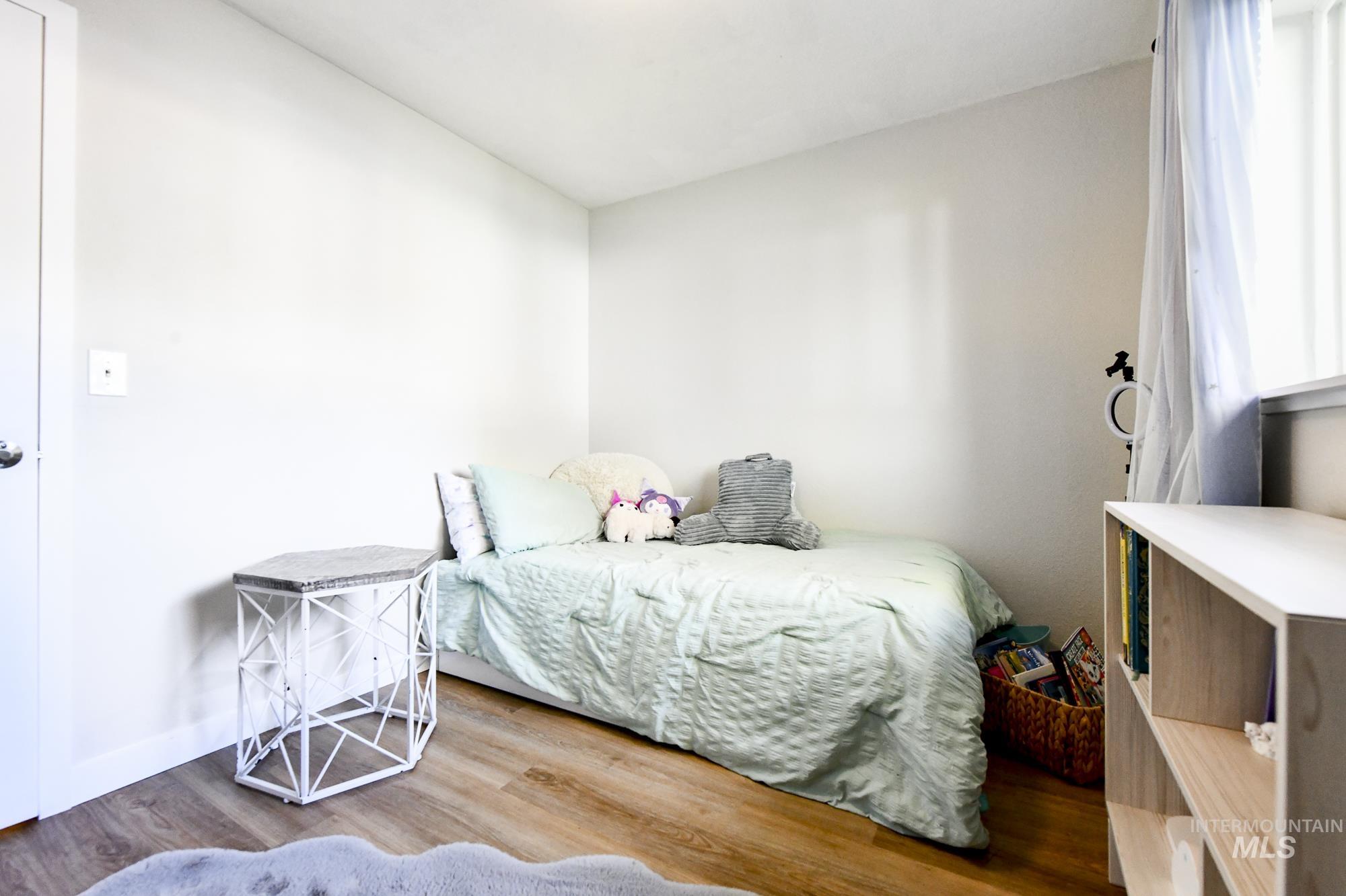 Bedroom featuring wood finished floors and baseboards