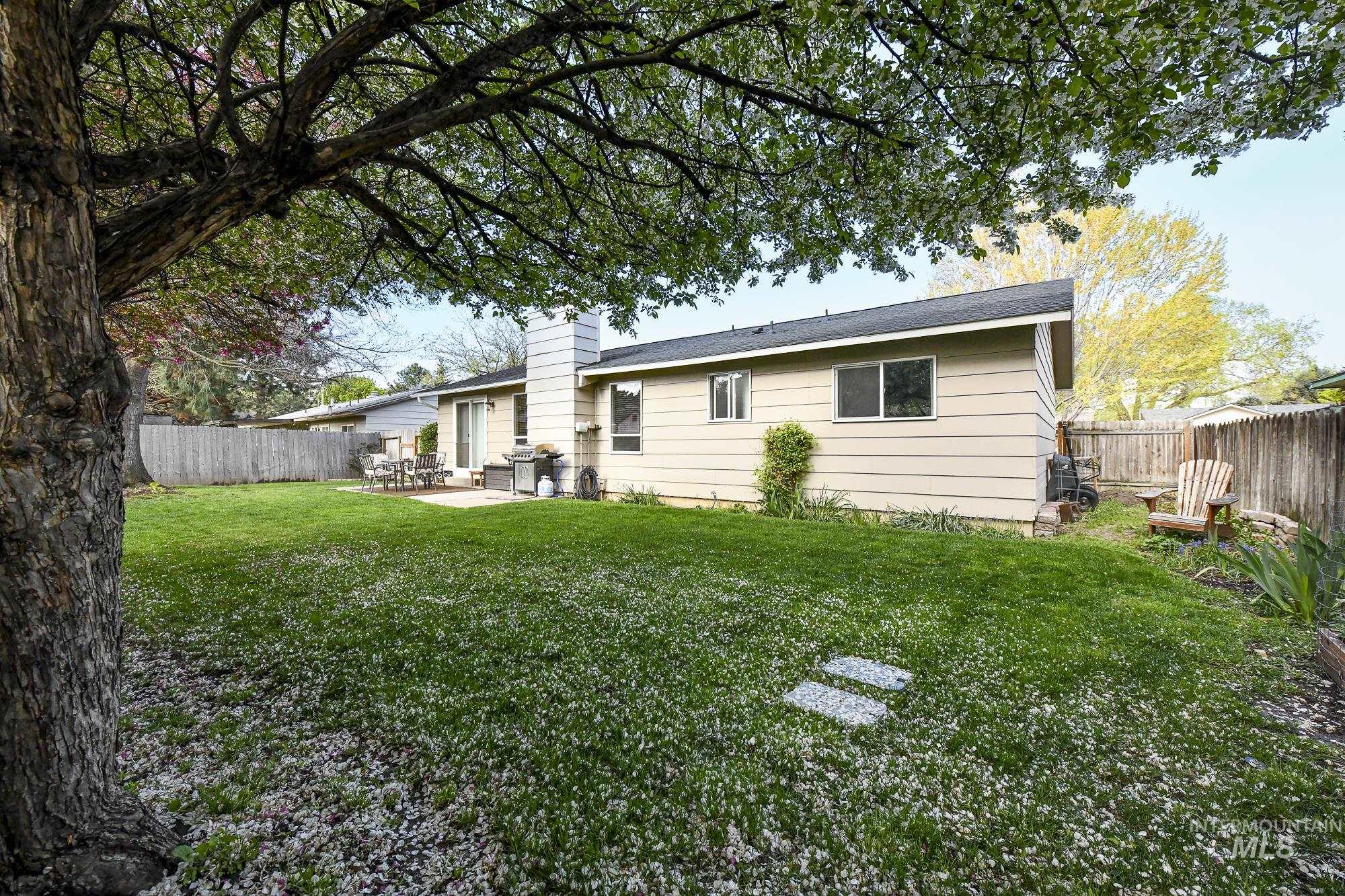 Rear view of house featuring a patio area, a fenced backyard, and a chimney