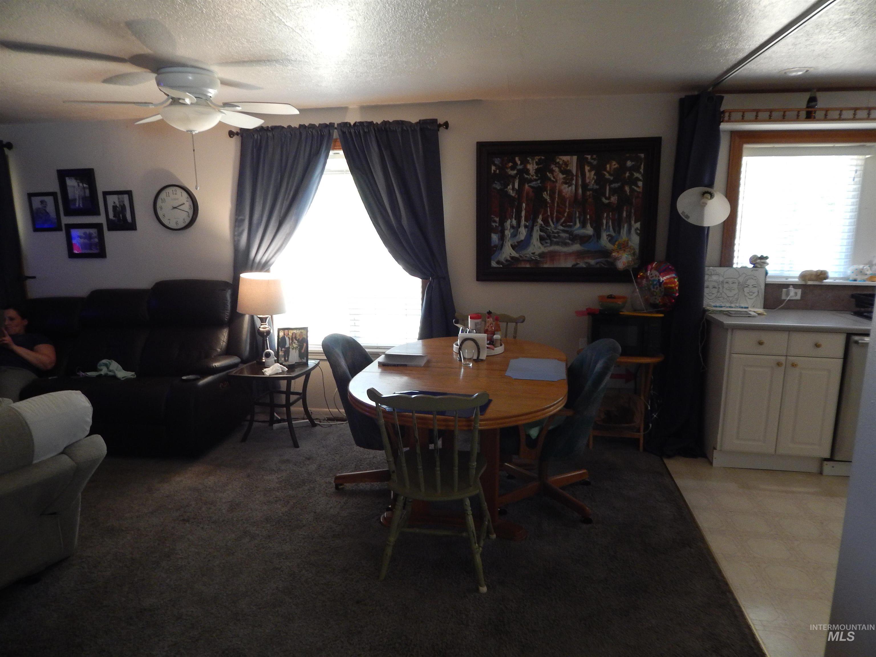 Dining room featuring a ceiling fan, a textured ceiling, and light floors