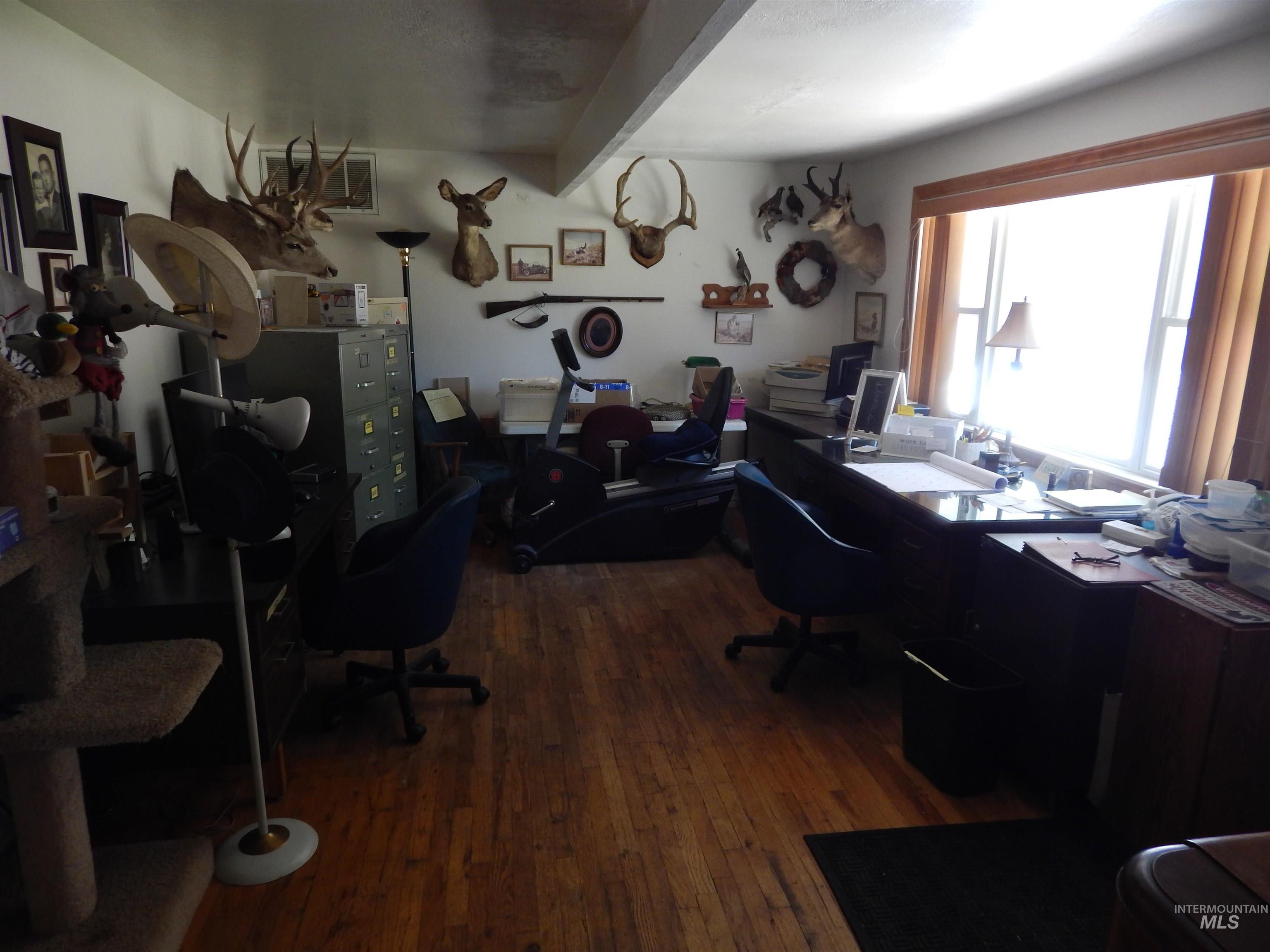 Office space with wood finished floors and beam ceiling