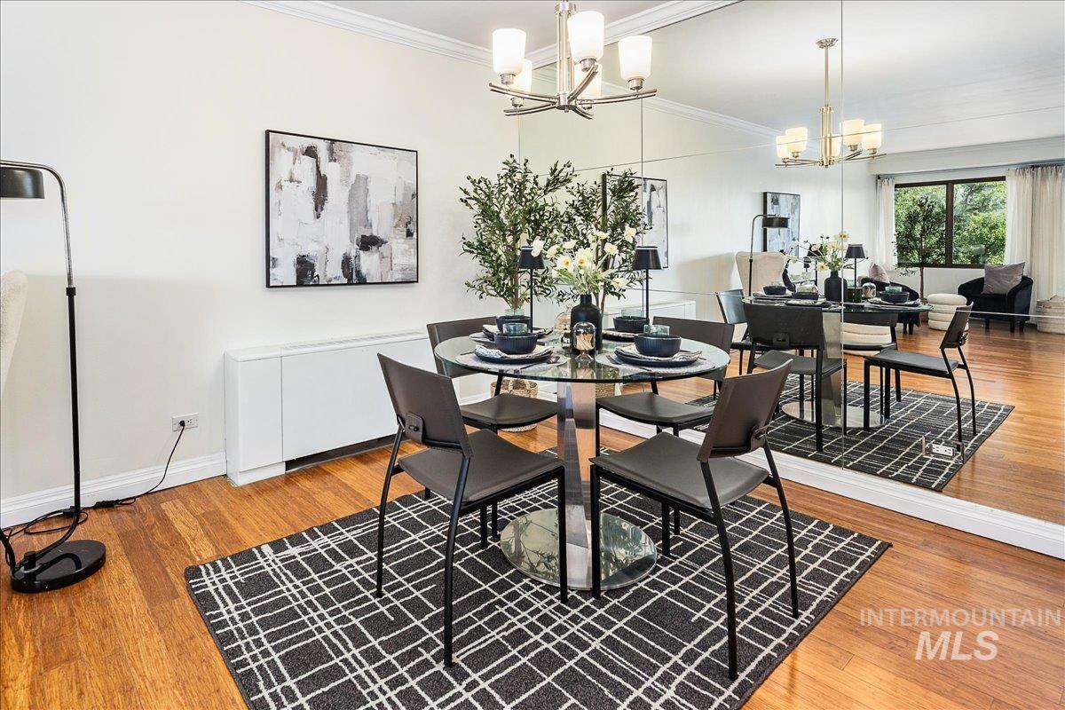 Dining room with crown molding, light wood finished floors, and a chandelier