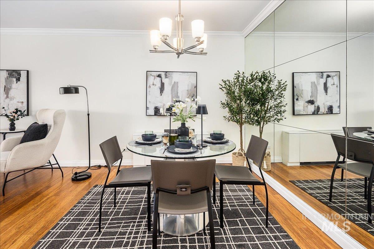 Dining area featuring crown molding, wood finished floors, and a chandelier