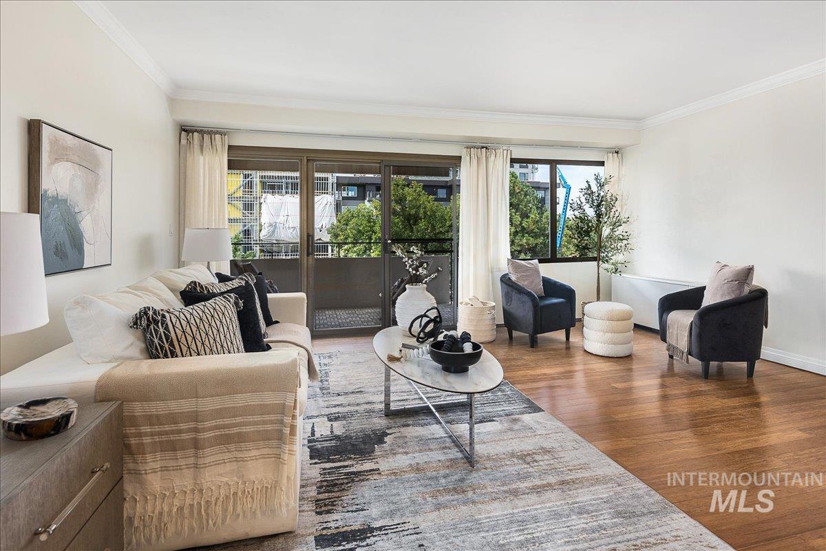 Living room with ornamental molding and wood finished floors