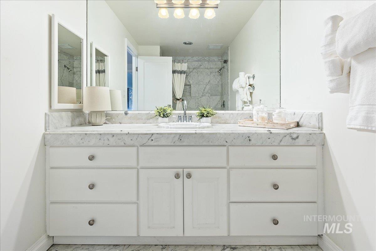 Full bathroom with vanity and tiled shower