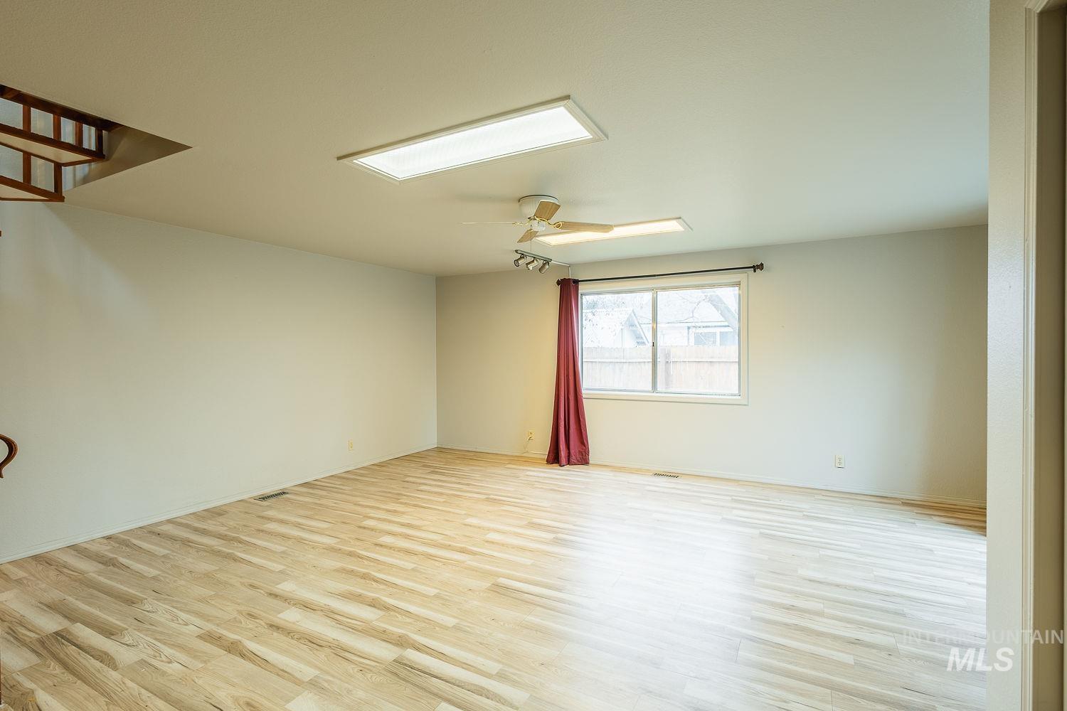 Unfurnished room featuring light wood-style floors and ceiling fan