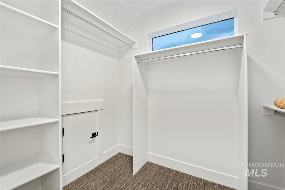 Spacious closet with dark carpet