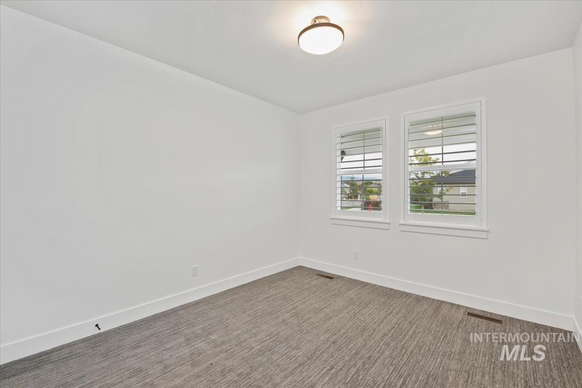 Carpeted empty room with baseboards