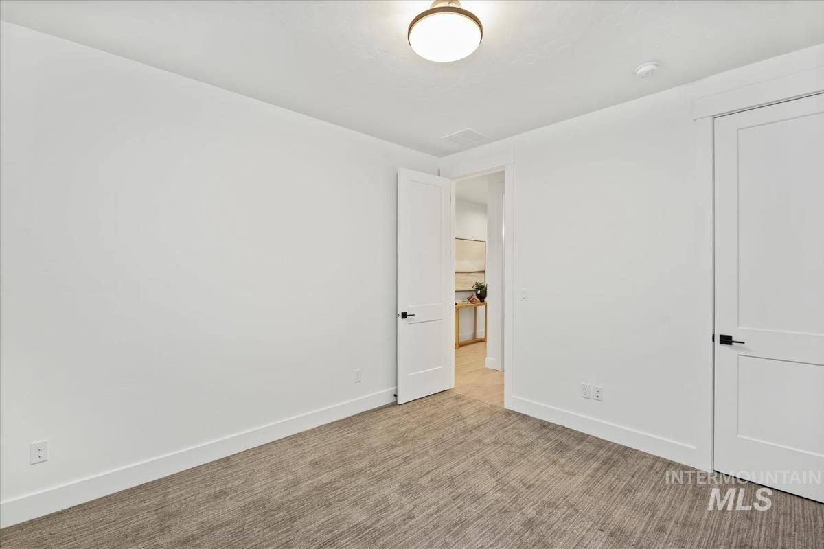 Unfurnished bedroom with carpet floors and baseboards