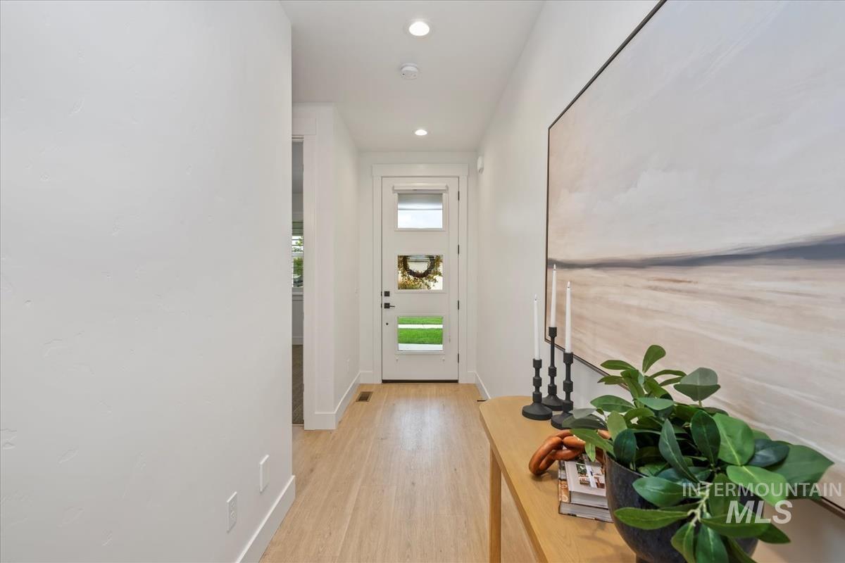 Doorway to outside with recessed lighting and wood finished floors