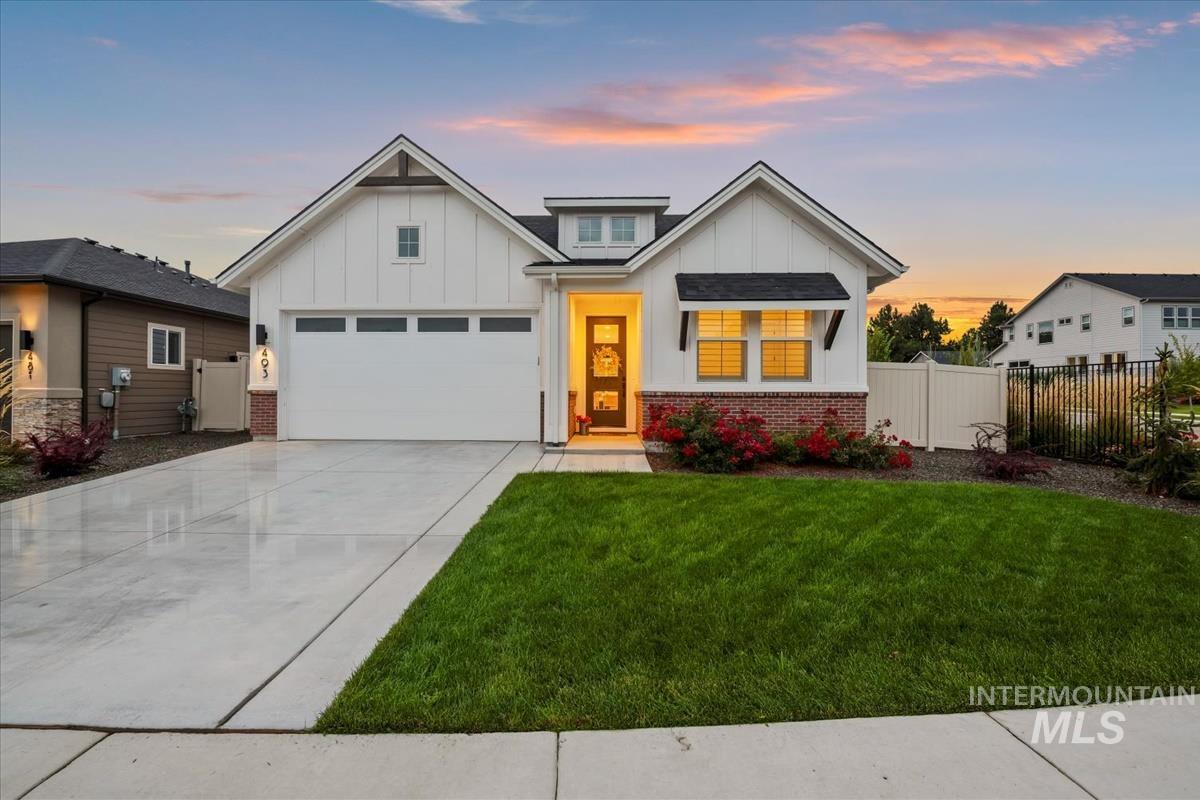 Modern farmhouse featuring board and batten siding, brick siding, and driveway