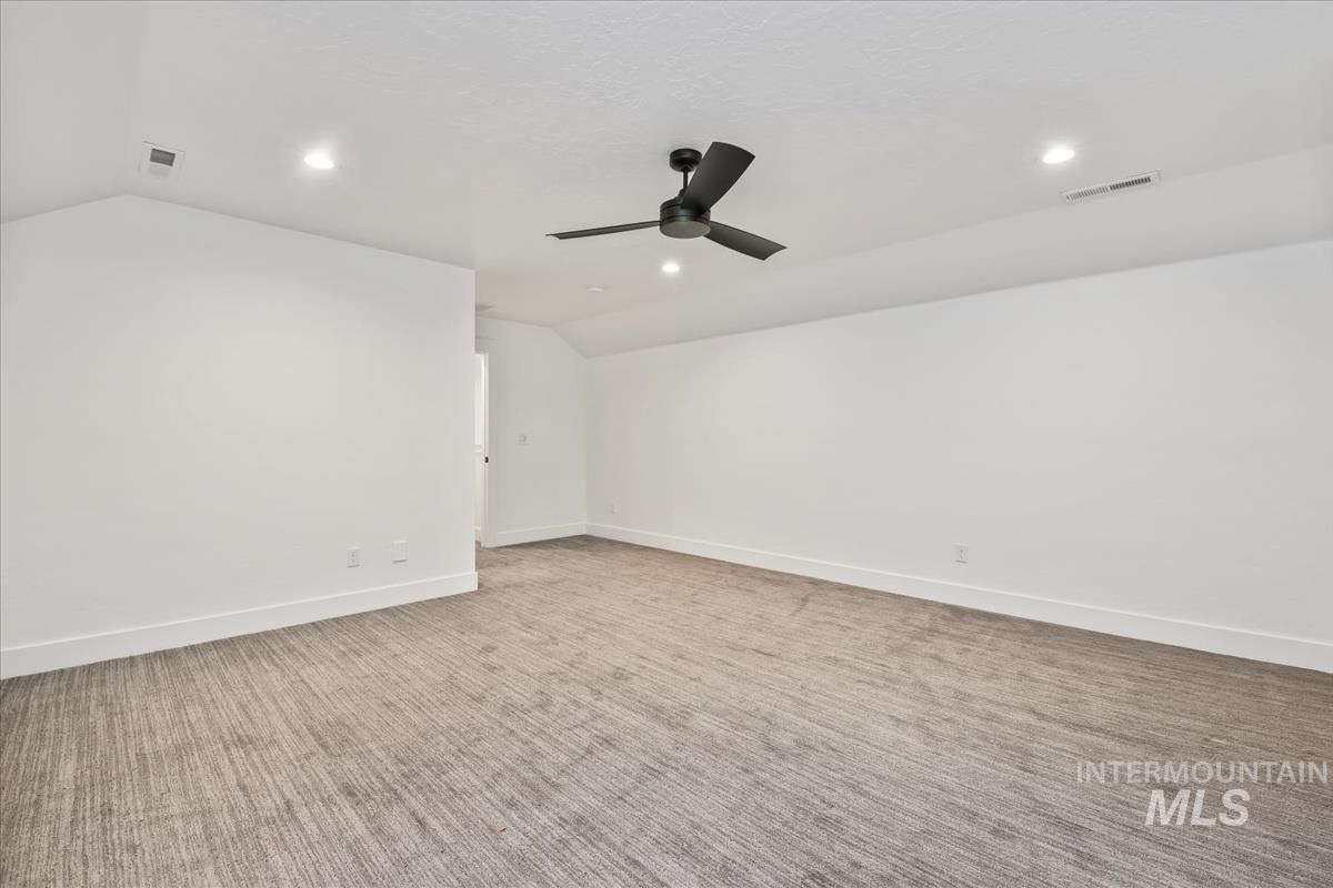 Unfurnished room featuring vaulted ceiling, light colored carpet, recessed lighting, and ceiling fan