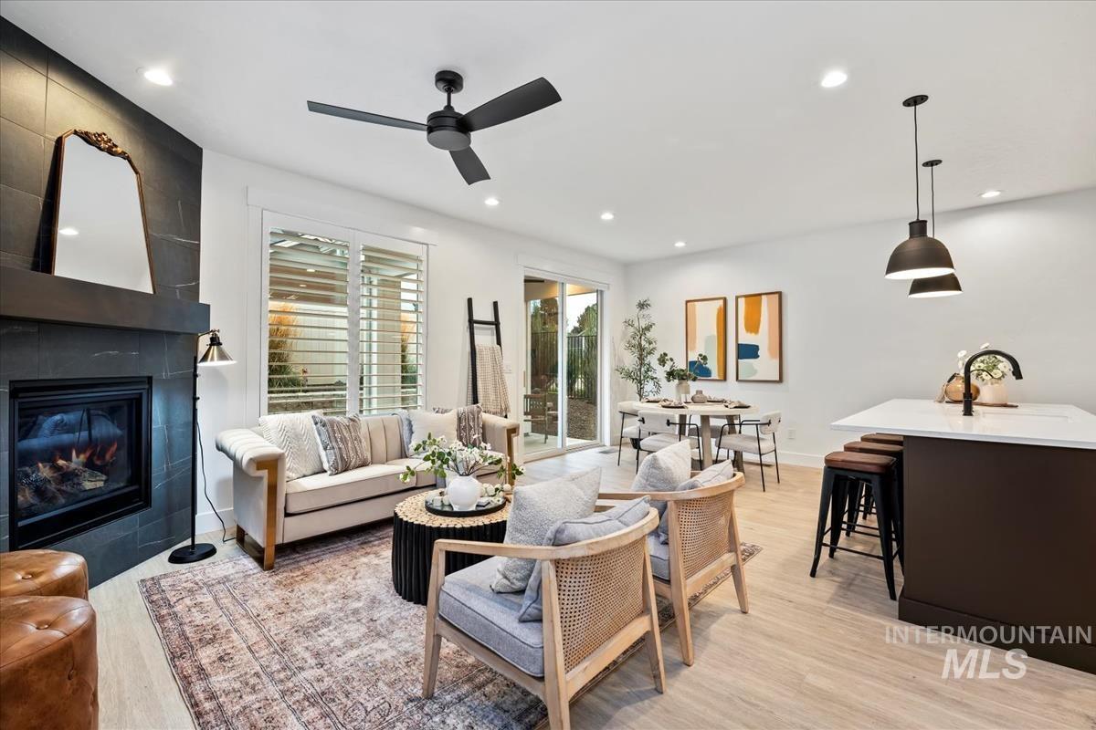 Living area with light wood-style floors, recessed lighting, and a tiled fireplace