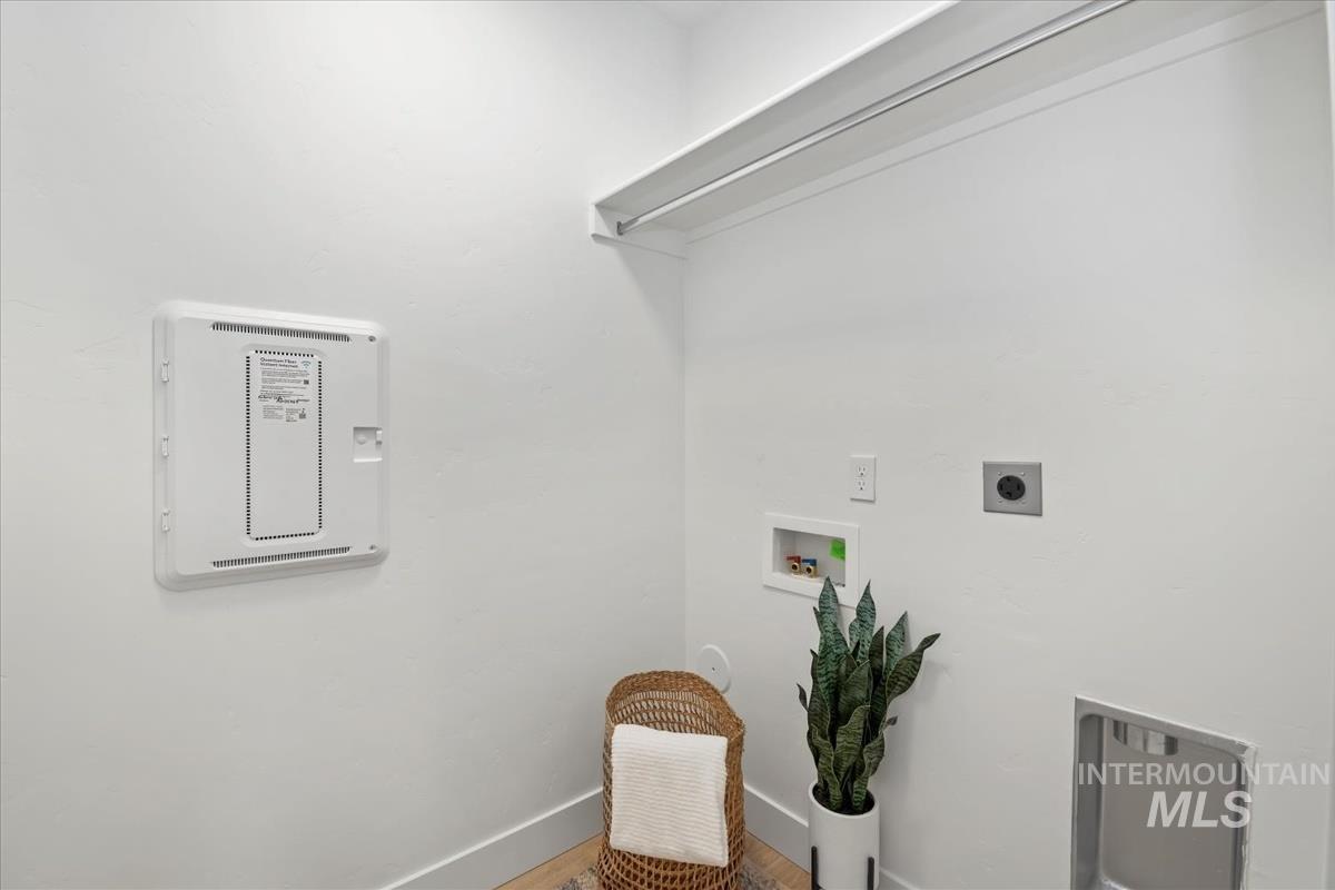 Laundry room featuring electric dryer hookup, washer hookup, and wood finished floors